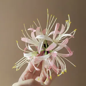 Close-up detail of a delicate pink and white fabric flower hair clip for styling.