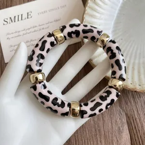 Macro detail of retro acrylic leopard print round bracelet with gold accent spacers