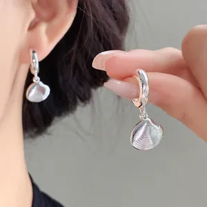 Vista dettagliata di orecchini a cerchio con pendente a conchiglia argento elegante