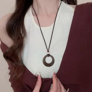 Vue détaillée d'un collier ethnique bohème avec pendentif anneau marron sur un mannequin