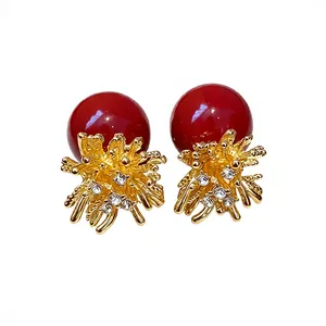 Elegant red pearl stud earrings featuring a gold firework floral rhinestone setting on white