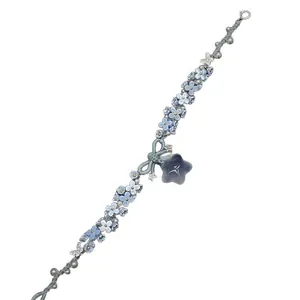 Handcrafted resin flower and star charm woven bracelet in light blue.