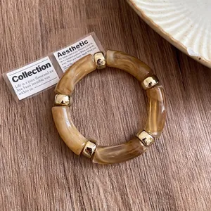 Detail view of a vintage amber marbled acrylic bracelet with polished gold spacers