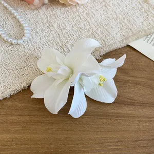 Close-up detail of elegant white fabric flower hair clip with realistic floral textures
