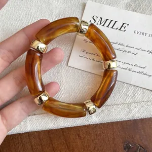 Detail view of a vintage amber acrylic bracelet with elegant gold-tone metal spacers.