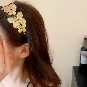 Dettaglio di un elegante cerchietto con farfalle in metallo dorato indossato da una modella