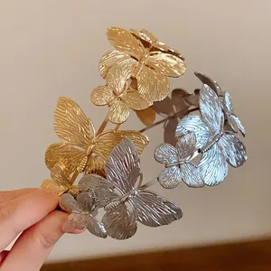 Vista dettagliata di eleganti cerchietti in metallo oro e argento con motivi a farfalla