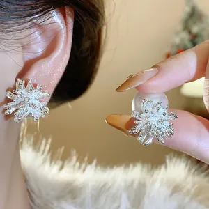 Close-up of elegant silver firework-shaped stud earrings with pearl details shown on an ear