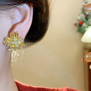Detailed close-up of elegant gold firework stud earrings with shimmering rhinestones