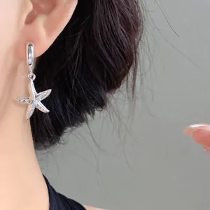 Dettaglio di orecchini a cerchio stella marina in argento, gioielli raffinati eleganti