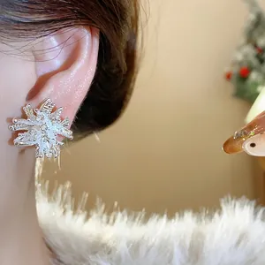 Close-up of elegant firework-shaped silver pearl earrings worn on a model's ear.
