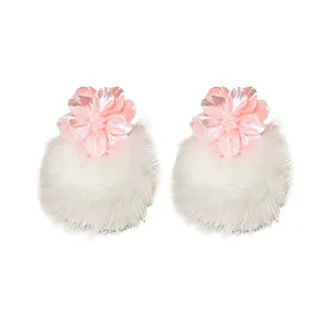 Eleganti orecchini a lobo con fiore in resina rosa e pompon bianco da donna alla moda.