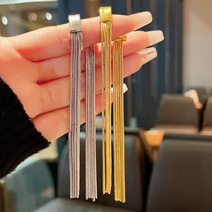 Detailed view of silver and gold metal tassel ear bone clips with elegant long chains
