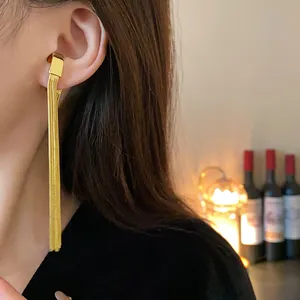 Elegant close-up showing the detail of a golden metal long tassel ear cuff on model