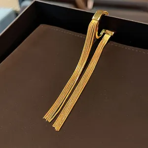 Detailed view of gold tassel ear cuff with elegant minimalist metal chain design