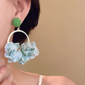 Sweet cloth petal hoop earrings featuring a green woven top and floral design