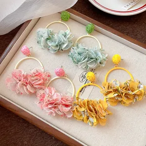 Detailed view of sweet fabric petal hoop earrings available in pink, green, and yellow.