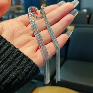 Close-up view of a minimalist silver metal tassel ear cuff with long elegant chains
