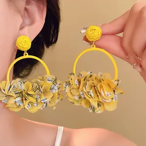 Close-up of yellow fabric floral hoop earrings featuring vibrant statement petals