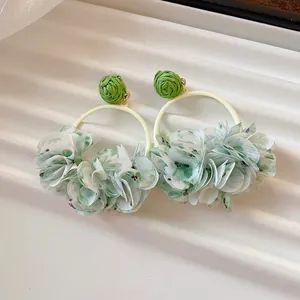 Detail showing sweet spring fabric flower petal hoop earrings with green woven studs