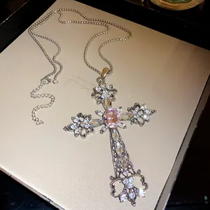 Détail du collier croix en argent vintage avec des strass roses et blancs étincelants