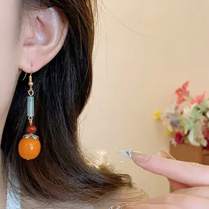 New Chinese style resin persimmon earrings with blue enamel cap detail on model