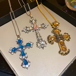 Gros plan de trois colliers croix vintage avec strass gouttes d'eau