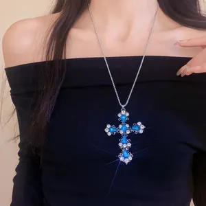 Détail du grand collier pendentif croix avec cristaux bleus et strass étincelants.