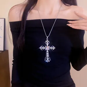 Vue détaillée d'un collier pendentif croix baroque avec strass roses sur un mannequin.