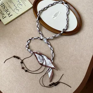 Detailed view of the woven silk scarf waist chain with dark brown wooden bead accents