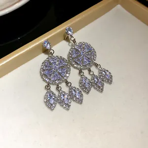 Makro-Detail von luxuriösen runden Silberohrringen mit funkelnden Strass-Quasten