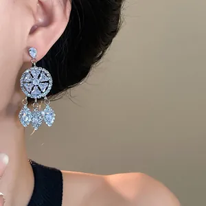 Detailansicht eleganter Silberohrringe mit runden Strasssteinen und Quastendesign