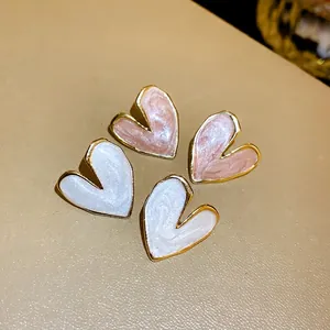 Elegant heart-shaped enamel stud earrings with gold-toned trim in pink and white