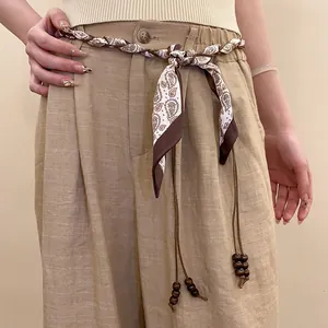 Detailed view of bohemian paisley print silk scarf woven belt with wooden beads