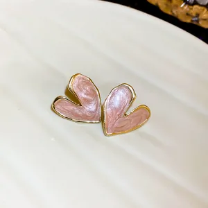 Close-up view of elegant pink heart-shaped earrings with gold trim and enamel finish