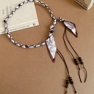 Detailed view of a retro ethnic fabric beaded waist chain with paisley tassels.
