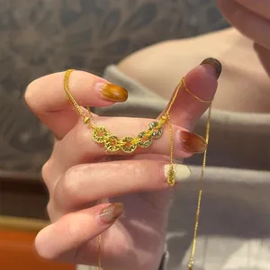 Gros plan d'un collier en or orné de cinq pièces de monnaie chinoises porte-bonheur.