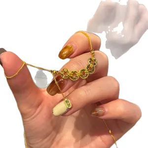 Élégant collier chinois en or avec pendentif porte-bonheur sur un charme blanc