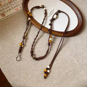 Detailed close-up view of handmade ethnic woven cord belt with beads and silver clasp