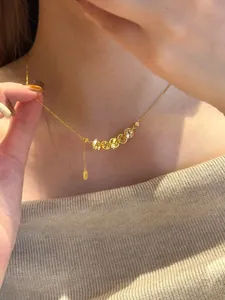Vue rapprochée d'un collier de pièces de cuivre doré porté sur un cou