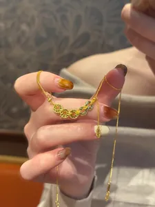 Vue détaillée d'un collier de pièces de cuivre chinoises dorées au style luxe vintage.
