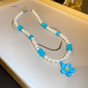 Double-layer pearl and blue bead necklace with a vibrant blue flower pendant charm