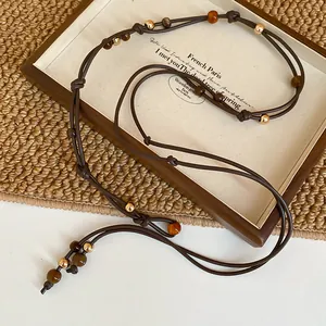 Vintage ethnic style beaded waist chain in dark brown cord with golden accents and tassels