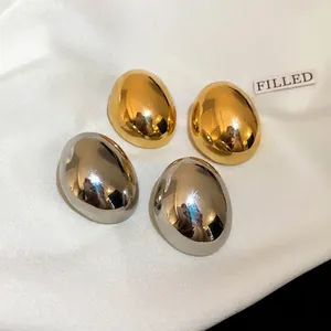 Pendientes de botón ovalados irregulares minimalistas chapados en oro y plata sobre raso