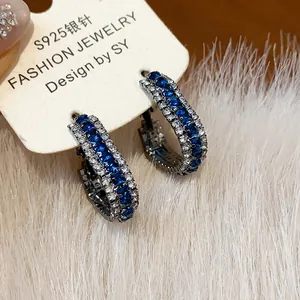 Detailed view of luxury geometric hoop earrings with blue and clear cubic zirconia