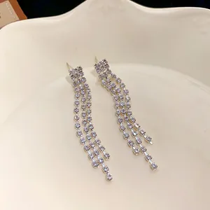 Detailed view of elegant silver tassel drop earrings with sparkling rhinestones.