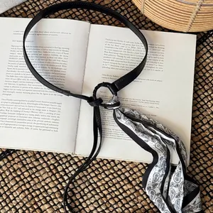 Close-up of vintage black and white paisley scarf belt with thin leather strap for women
