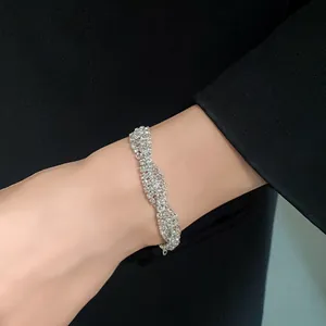 Close-up of elegant multi-layer rhinestone bracelet worn on wrist over black suit