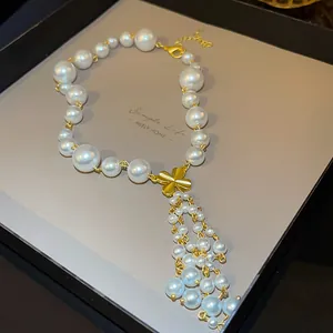 Close-up of pearl necklace with gold flower pendant and elegant pearl tassels