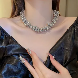 Close-up detail of a silver metallic bead cluster necklace worn by a model on her neck.